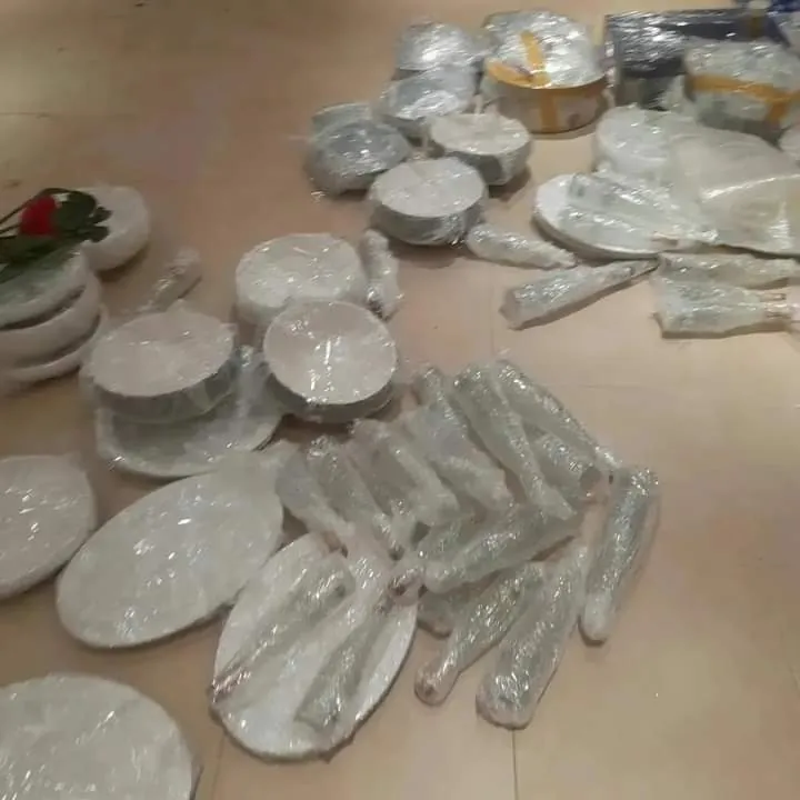 أطباق وأدوات مطبخ مغلفة بالنايلون ومرصوصة على الأرض